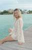 Short swimsuit cover with floral lace fabric for vacation.